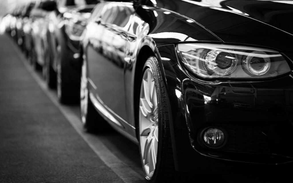pexels-photo-70912-70912 Close-up black and white image of a luxury car line-up focusing on vehicle headlights.